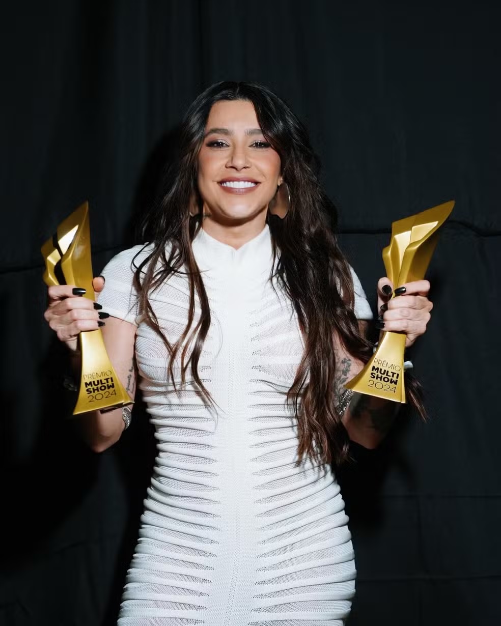 Cantora Lauana Prado segurando os 2 troféus que ganhou do Prêmio Multishow 2024. 